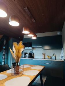 a kitchen with a wooden table and blue cabinets at Le havre du lac in Vielsalm +39 photos
