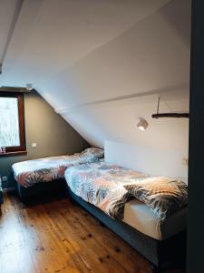 two beds sitting next to each other in a room at Le havre du lac in Vielsalm