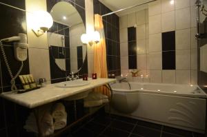 a bathroom with a sink and a tub and a mirror at Delphi Art Hotel by Prima Hotels in Athens
