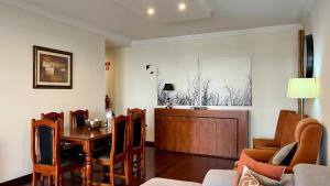 een woonkamer met een houten tafel en een eetkamer bij Madeira Emotions Apartments in Funchal