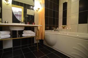 a bathroom with a tub and a sink and a mirror at Delphi Art Hotel by Prima Hotels in Athens