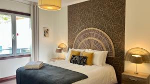 een slaapkamer met een groot bed en een grote muur bij Madeira Emotions Apartments in Funchal