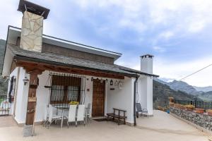 a white house with a table and chairs on a patio at Casa Javi in Ojedo