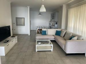 a living room with a couch and a tv at Aneta's Beach House in Vlorë