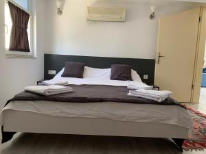 Un dormitorio con una cama grande con cabecero negro. en Kalkan Şener Apart, en Kas