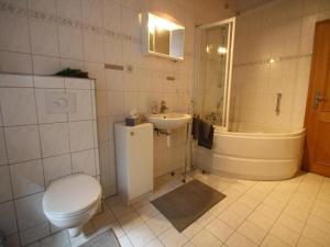 a bathroom with a toilet and a sink and a tub at Doppelhaushälfte, Glave in Glave +8 photos