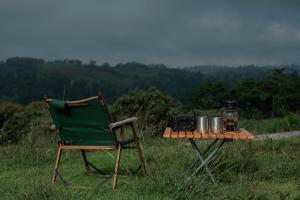 a green chair and a table with a radio on it at Monoshez Bush Camp in Nsikazi