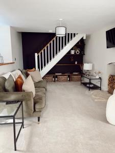 un salon avec un canapé et un escalier dans l'établissement The Potting Shed, à Chepstow