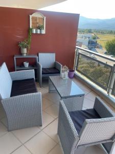 a patio with chairs and tables on a balcony at Lovely apartment cosmopoli in Komotini +5 photos