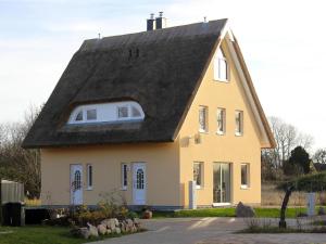 una casa amarilla con techo negro en Ferienhaus Breetzer Boddentraum in Vieregge, en Vieregge
