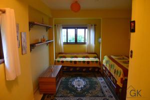 a small room with two beds and a window at Chalé Schueler in Nova Friburgo