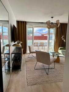 a living room with a table and chairs at Charmant appartement T3 contemporain au bord de l'eau sur le Bassin Arcachon in Lanton