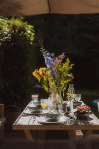 a table with a vase of flowers on it at Agapella Apartamenty- Sopot Cottage Ogród 400m od plaży 6 dorosłych i dzieci in Sopot