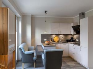 a kitchen with white cabinets and a table and chairs at Exclusives Appartement auf Fehmarn in Petersdorf auf Fehmarn +32 photos
