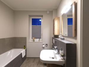 a bathroom with a sink and a bath tub and a sink at Exclusives Appartement auf Fehmarn in Petersdorf auf Fehmarn