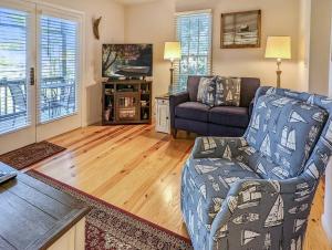 a living room with a couch and a chair at Marsh Point - Screened Porch & Shared Dock! in Black Point Landing