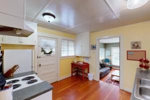 a kitchen and living room with yellow walls and wooden floors at Molalla River Cottage in Molalla