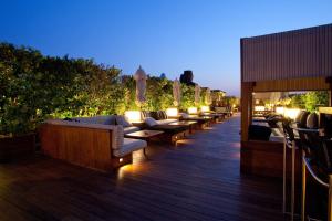 a deck with couches and tables and lights at Hotel 1898 in Barcelona