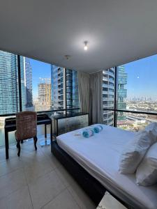 a bedroom with a bed and a desk with a view at Click Stay - JLT - 2 Bedroom & Balcony Lakes View Entire Apartment -SS in Dubai