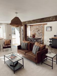 ein Wohnzimmer mit Sofa und Tisch in der Unterkunft Gardener's Cottage in Chepstow