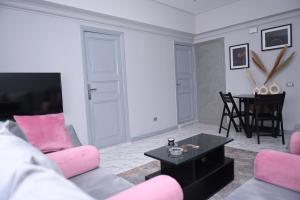 a living room with pink furniture and a table at Belle Helen - Bright Independent Apartment in Cairo