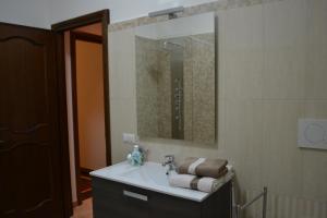 a bathroom with a sink with a mirror and towels at B&B Visconti in Lido di Ostia