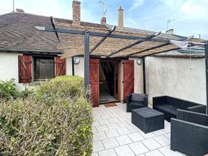 a house with a patio with two chairs and an open door at Maison 3 chambres in Villemandeur