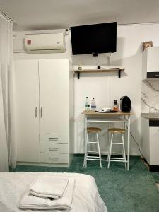 een slaapkamer met een bed en een tafel met 2 krukken bij The Box in Iaşi
