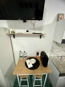 een kleine tafel met twee stoelen en een televisie aan de muur bij The Box in Iaşi