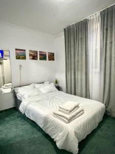 een slaapkamer met een wit bed met handdoeken erop bij The Box in Iaşi