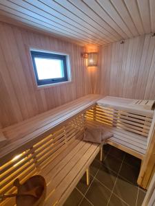 eine Holzbank in einer Sauna mit Fenster in der Unterkunft Large Modern Family Cottage in Lifjell
