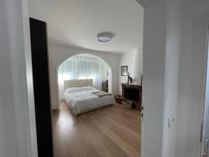 a bedroom with a bed and an arched doorway at D&D Apartments in Tirana