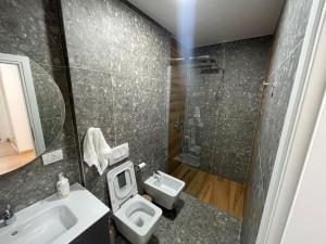 a bathroom with a toilet and a sink and a shower at D&D Apartments in Tirana +20 photos