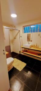 a bathroom with a white toilet and a sink at Chácara Sitara Lazer e Eventos in Caldas
