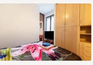 a room with a bed with a pink flower on it at Bilocale Desenzano in Desenzano del Garda