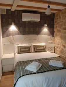 a bedroom with a white bed with two pillows at Casa Marisa Padron, Camino de Santiago in Padrón