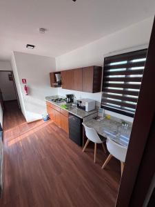 a kitchen with a table and chairs in a room at Hotel Playa Los Angeles Bungalow Ohana in Ciudad del Carmen