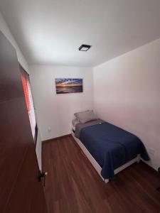 a bedroom with a bed and a painting on the wall at Hotel Playa Los Angeles Bungalow Ohana in Ciudad del Carmen