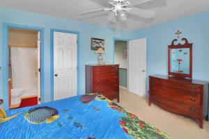 1 dormitorio con 1 cama, vestidor y ventilador de techo en Misty's Thicket - Water access; Screened porches!, en Black Point Landing