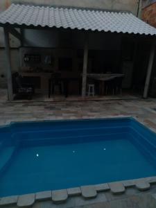 een blauw zwembad voor een huis bij Pousada por do sol in Niterói
