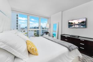 a white bedroom with a large window and a bed at 4B Super Premium Private Condo at the Setai in Miami Beach