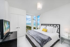 a white bedroom with a bed and a television at 4B Super Premium Private Condo at the Setai in Miami Beach