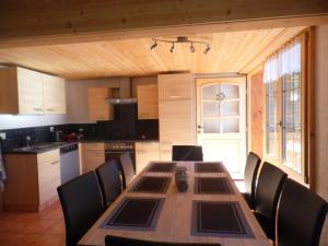 uma cozinha com uma longa mesa de madeira e cadeiras em Appartment Chalet Sonnenheim em Kandersteg