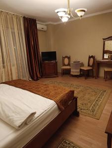 バイレ・ウヌ・マイにあるPensiunea Lariのベッドとテーブルと鏡のある寝室