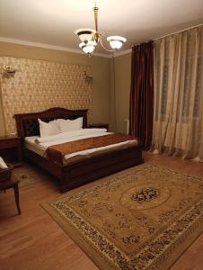 バイレ・ウヌ・マイにあるPensiunea Lariの大きなベッドとラグのある寝室