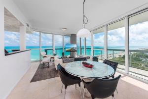 a dining room with a table and chairs and the ocean at Oceanfront Private Condo at The Setai -2208 in Miami Beach