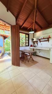 a kitchen with a table and a dining room at Casa Jardim Bangalos in Paraty