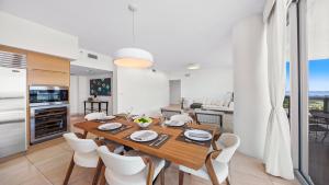 a kitchen and dining room with a wooden table and chairs at Oceanview Private Penthouse Condo at The Setai -3903 in Miami Beach