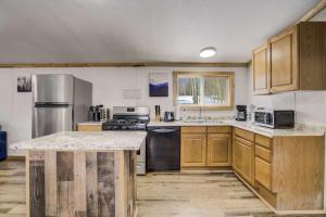 a kitchen with wooden cabinets and stainless steel appliances at Gold Dust Cabin Family Escape with Scenic Views in Cripple Creek