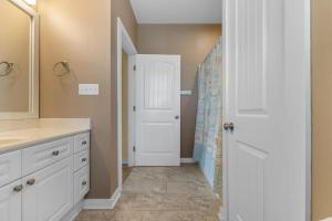 a bathroom with a sink and a white door at A 4 Bedroom House in Gated Litchfield By the Sea in Pawleys Island +29 photos
